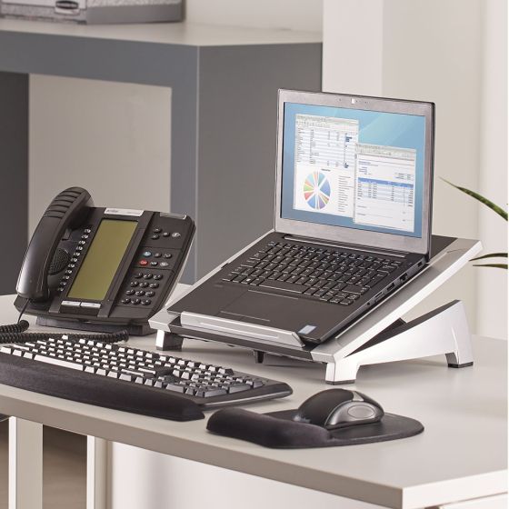Office Suites™ Laptop Riser - lifestyle shot, shown with a laptop, separate keyboard and mouse, in an office environment