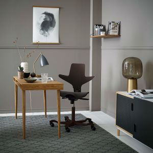HÅG Capisco Puls 8020 Ergonomic Office Chair - lifestyle shot, showing the black chair with a black base in a home office environment