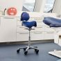 Score Amazone Balance Saddle Stool with Backrest - lifestyle shot, shown in a clinical environment