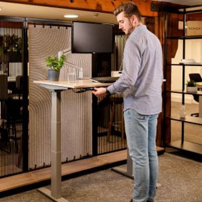 JOSHO Homeworker Beech Electric Sit-Stand Desk - lifestyle shot, shown raised in the standing position
