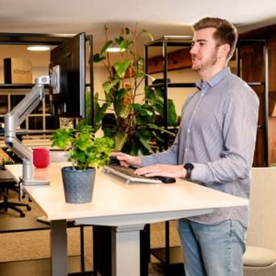 JOSHO Homeworker Light Maple Electric Sit-Stand Desk - lifestyle shot close up, shown raised in the standing position