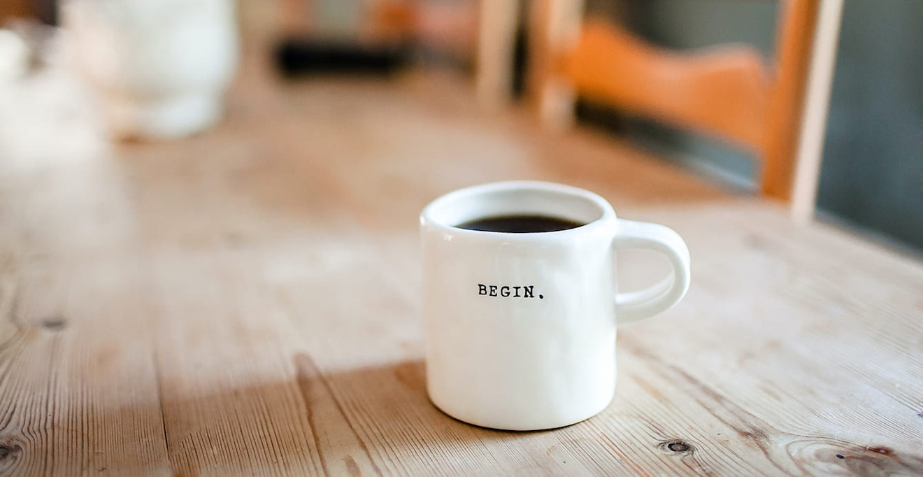 Mug of coffee with the word 'Begin' on it