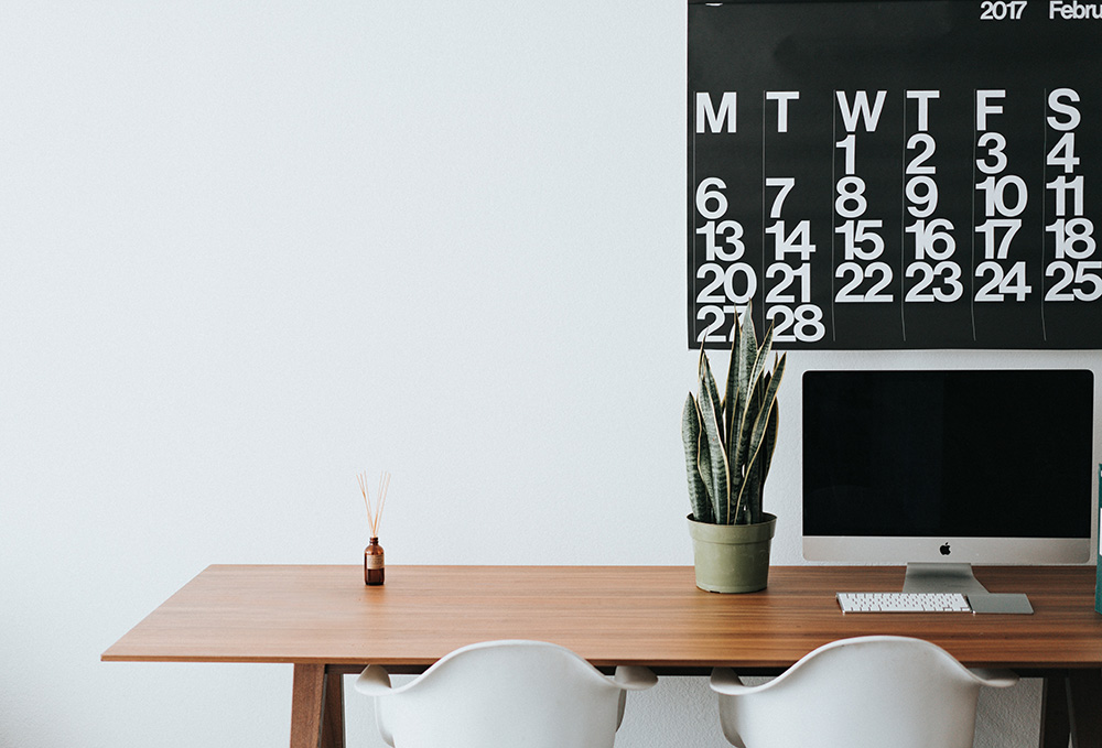 Office desk with large calendar on the wall