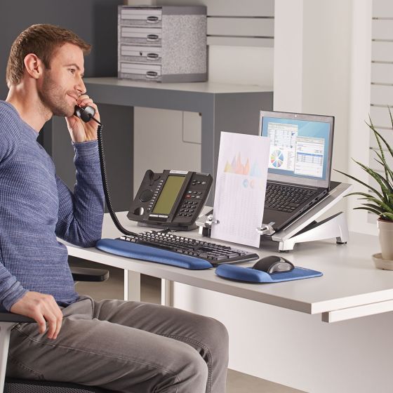 Office Suites™ Laptop Riser Plus - lifestyle shot, shown with a laptop, separate keyboard and mouse, in an office environment