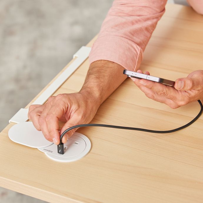 Desk Power Grommet Socket - white, lifestyle shot showing a phone charging