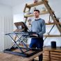 Lifestyle shot of a man using the Deskrite 100E Sit-Stand Platform when standing