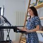 Lifestyle shot of a woman using the Deskrite 100E Sit-Stand Platform when standing, showing a close up of the keyboard tray