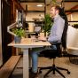 JOSHO Homeworker Beech Electric Sit-Stand Desk - lifestyle shot, shown lowered in the seated position