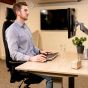 JOSHO Homeworker Beech Electric Sit-Stand Desk - lifestyle shot, shown i use with a monitor arm, keyboard and mouse