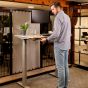 JOSHO Homeworker Beech Electric Sit-Stand Desk - lifestyle shot, shown raised in the standing position