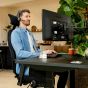 JOSHO Homeworker Electric Sit-Stand Desk - lifestyle shot - black desk and frame, side angle view, showing seated position