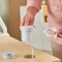 Desk Power Grommet Socket - white, lifestyle shot showing how to place socket into desk grommet