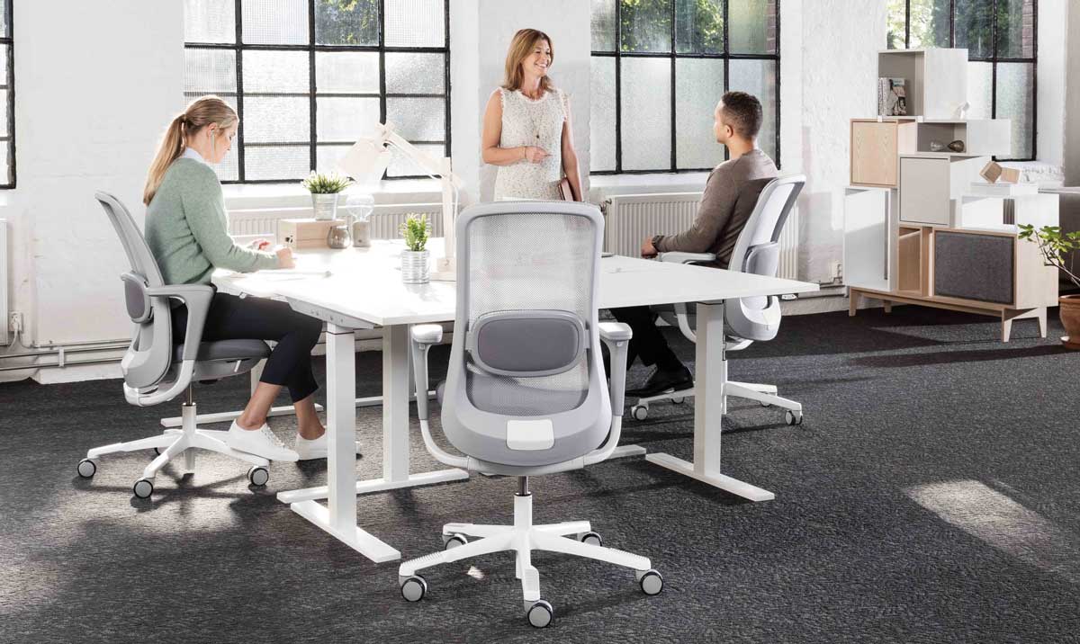 Meeting room showing people sitting in HÅG SoFi mesh back chairs around a square table