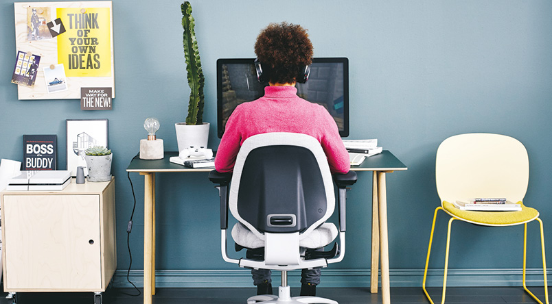 Woman working at her home working desk while sitting on a RH Mereo 220 chair