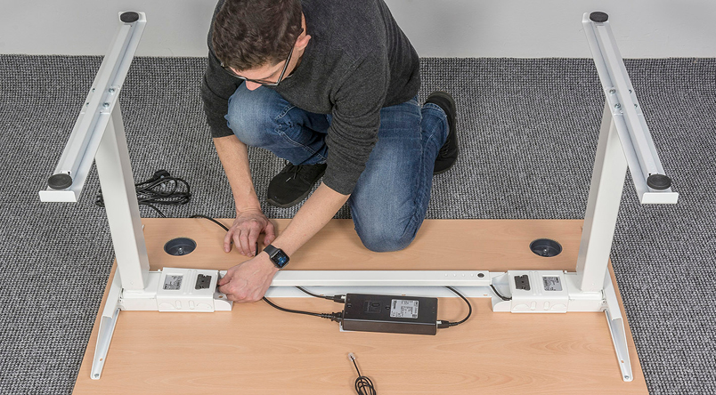 Image of man setting up and building the DeskRite 550 Sit-Stand Desk