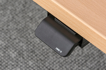 Close up image of the height adjustment pad on the desk