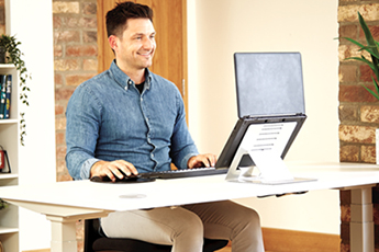 Image of man happily working on his desk using the Hylyft Laptop Stand with his Laptop