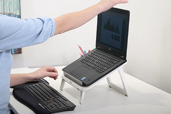Image of person setting up I-Spire Series Laptop at their desk workstation 