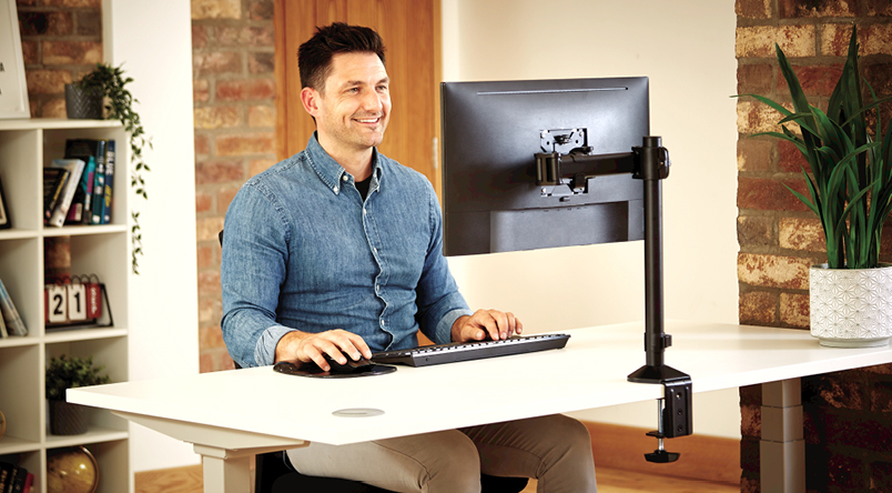 Image of a man enjoying working at his desk, with him using the Reflex Monitor Arms