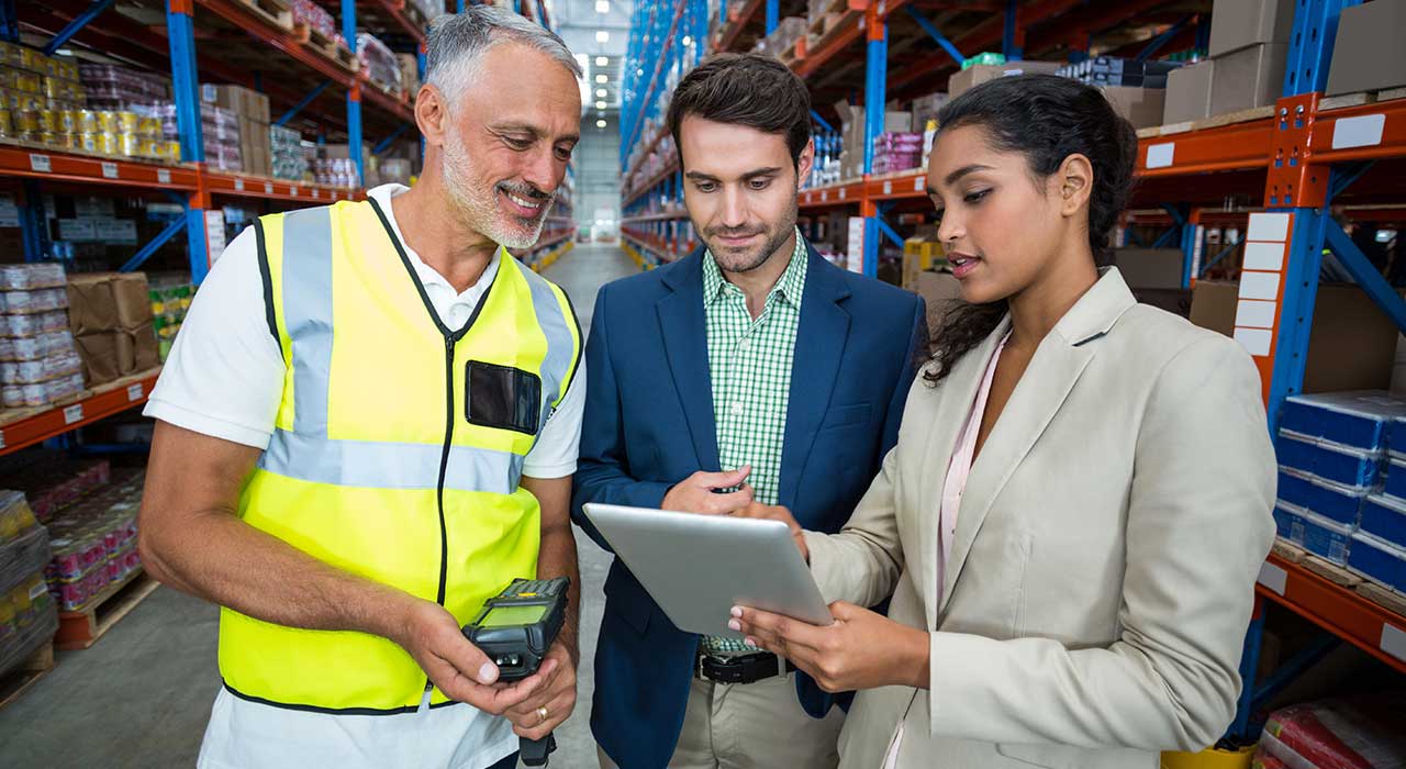 Warehouse staff discussing work on a mobile device