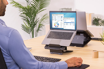 Lifestyle image of the Breyta™ Laptop Stand, shown in use with a separate keyboard and mouse