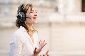Image of a woman using the Tilde® Pro C+ Noise-Cancelling Bluetooth Headphones with the microphone