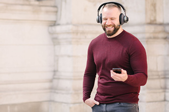 Image of a man outside using the Tilde® Pro C+ Noise-Cancelling Bluetooth Headphones during a call