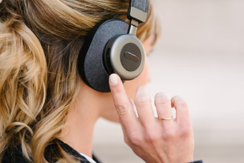 Close up of a woman changing the noise-cancellation setting on the Tilde® Pro C+ Noise-Cancelling Bluetooth Headphones
