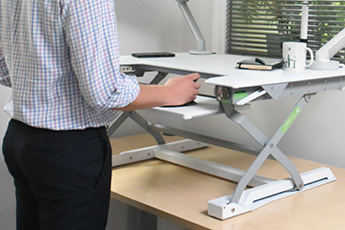 Close up shot of a person using the DeskRite 100 Sit-Stand Platform