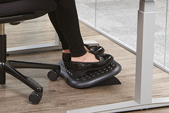 Lifestyle image of the Footmate Footrest, shown in use while sitting at a desk