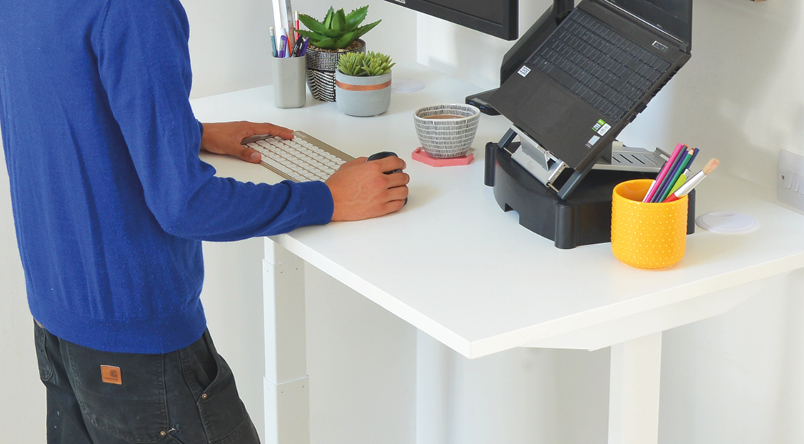 Image of a man standing using the Josho Electric Sit-Stand Desk