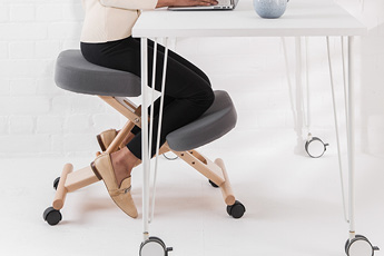 The Putnams Kneeling Chair, showing how it can improve posture when working at a desk