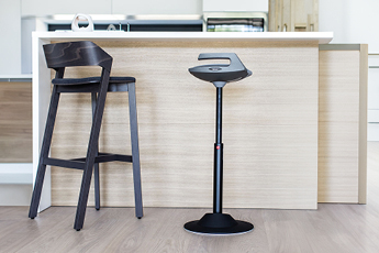 Lifestyle image of the Muvman Standing Chair, showing how it fits effortlessly in a home environment