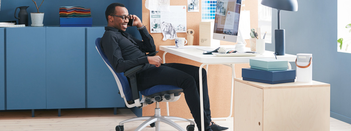 Man sitting in an ergonomic chair and chatting on his mobile phone